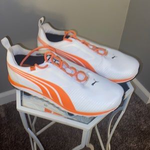 Size 10, orange and white Puma golf shoes.